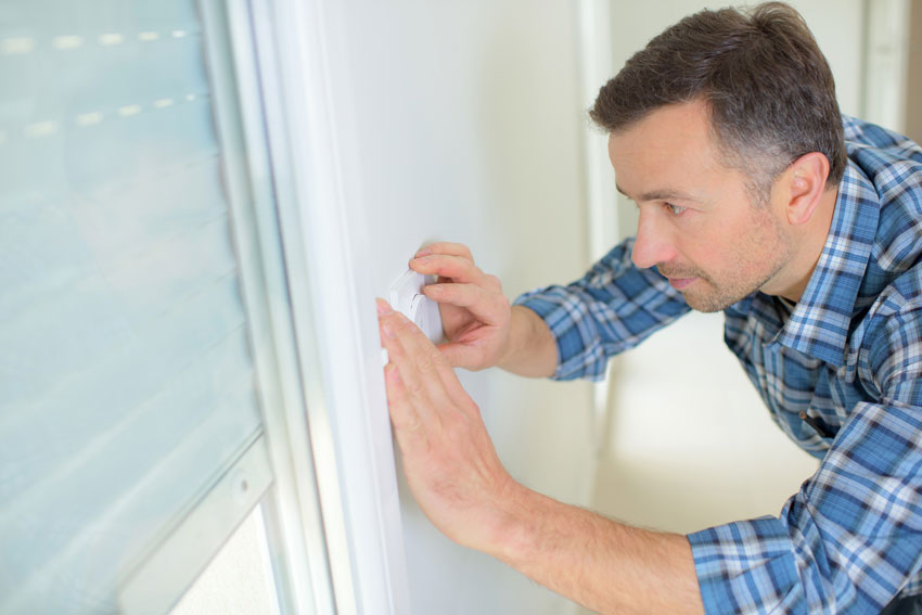 Klebestreifen an einem Fensterrahmen